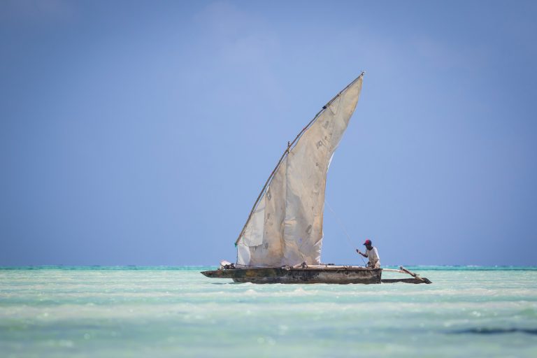A dhow under sail on turquoise water