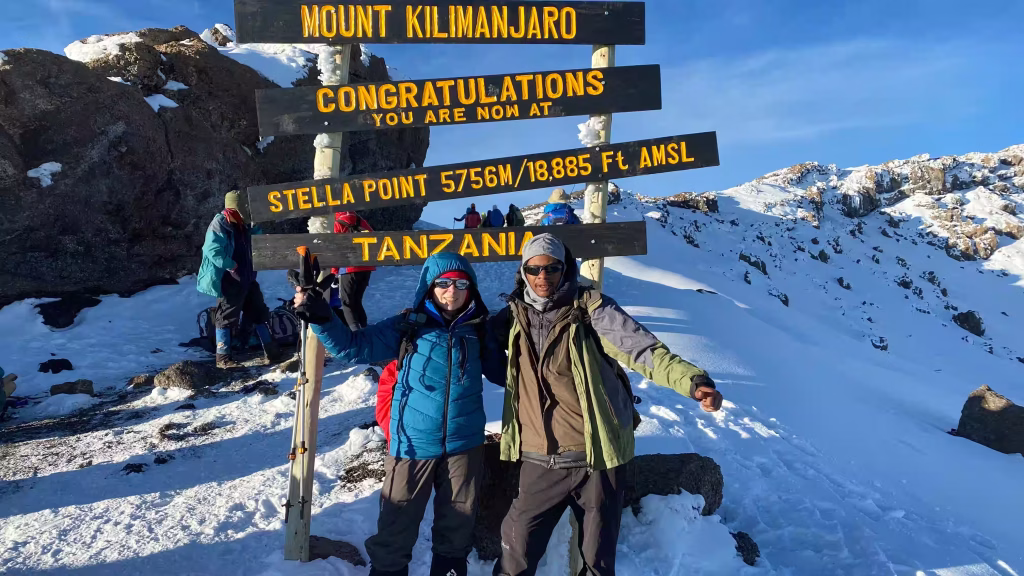 Climbers at the summit sign on Kilimanjaro