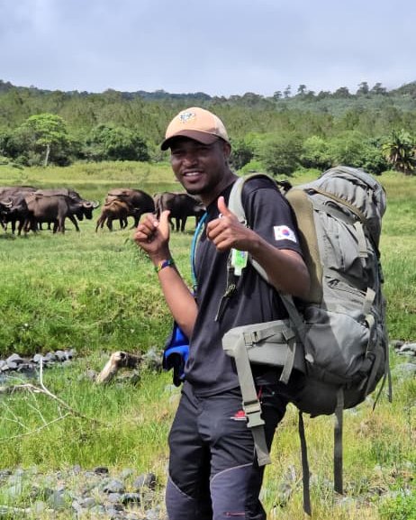 Gregory Sulle, mountain and tour guide, beside buffalo on the plains