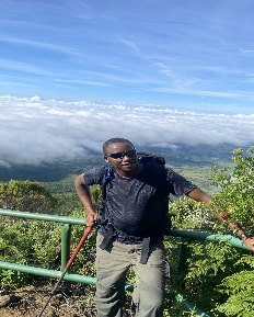 Samuel Muma, mountain and tour guide, at a viewpoint above the clouds