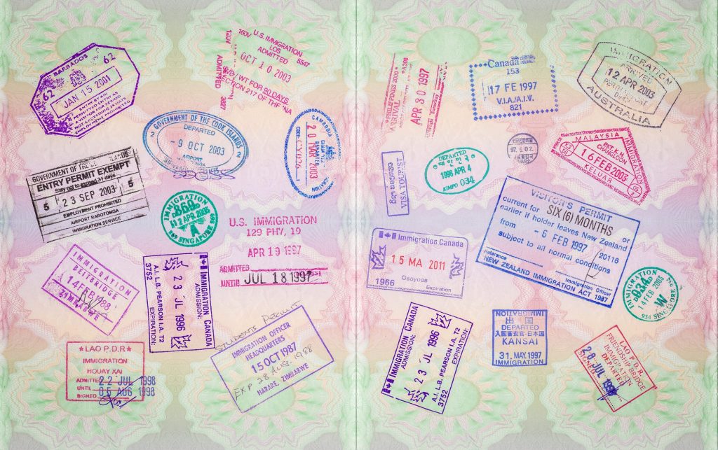 Open passport pages covered in immigration stamps